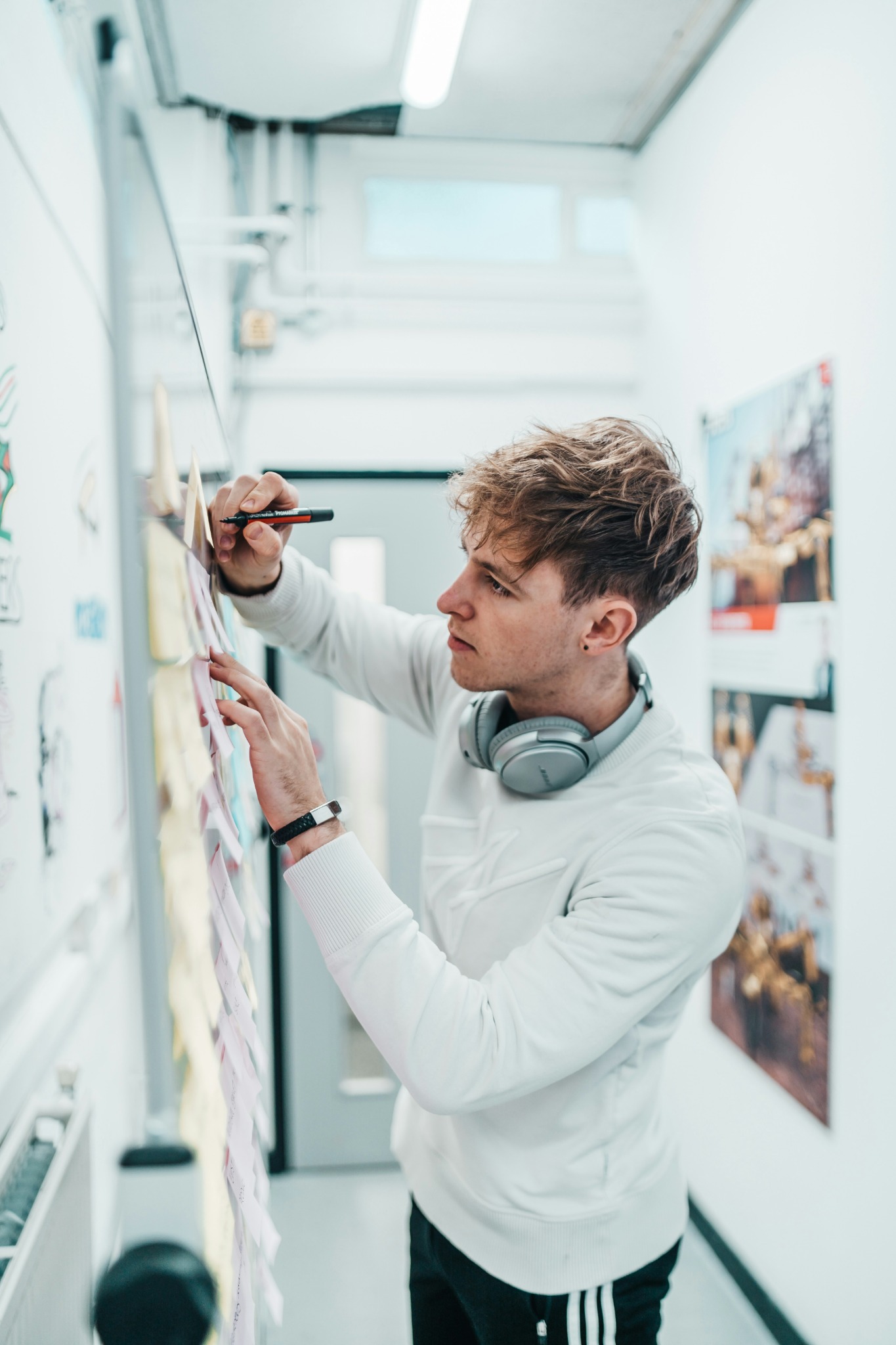Designer arbeitet mit einem Stift an Entwürfen an einer Wand.